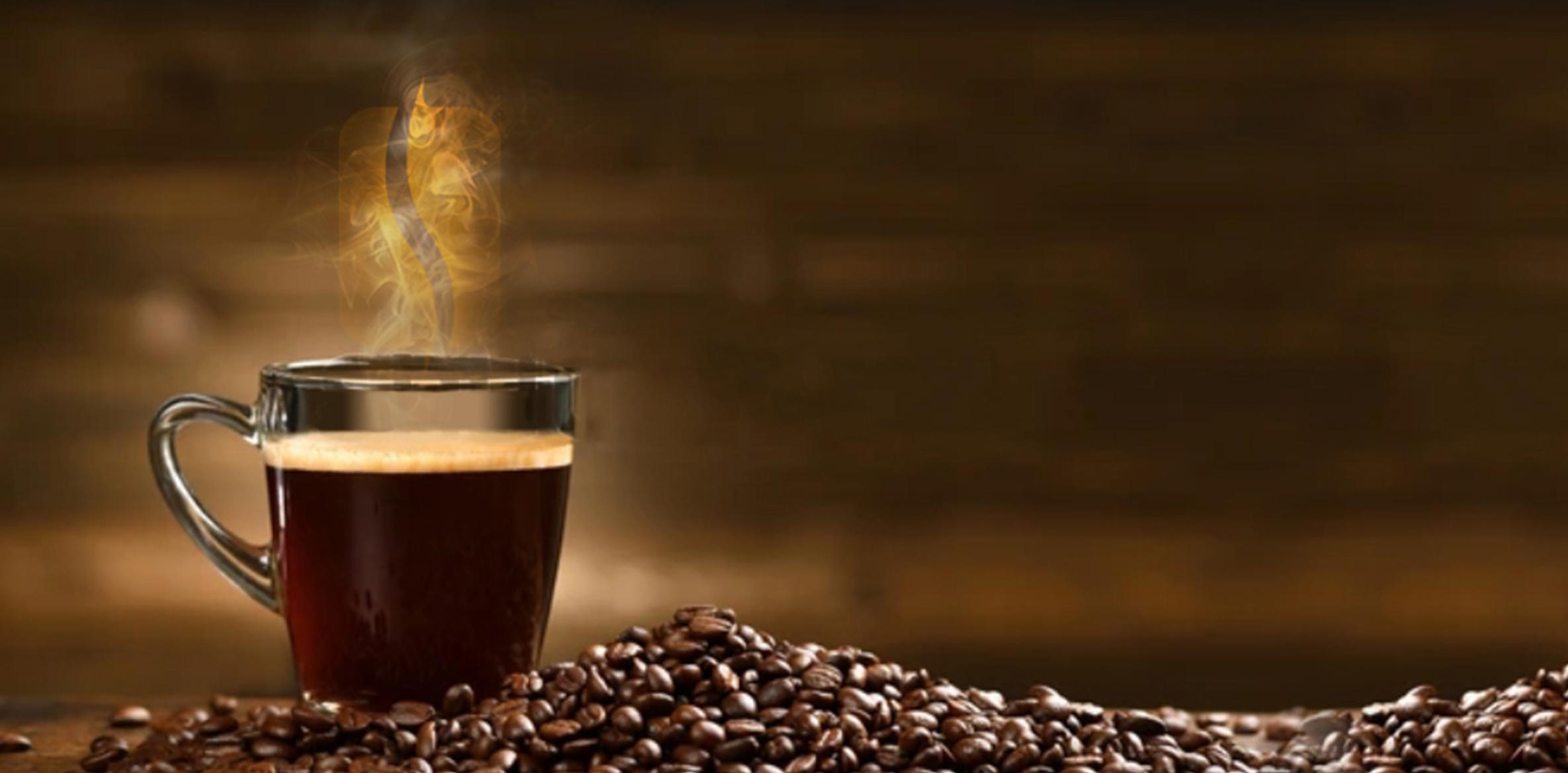 Steaming cup of coffee on a rustic wood table surrounded by roasted coffee beans, representing Ricco Coffee’s warm, artisan approach to craft roasting