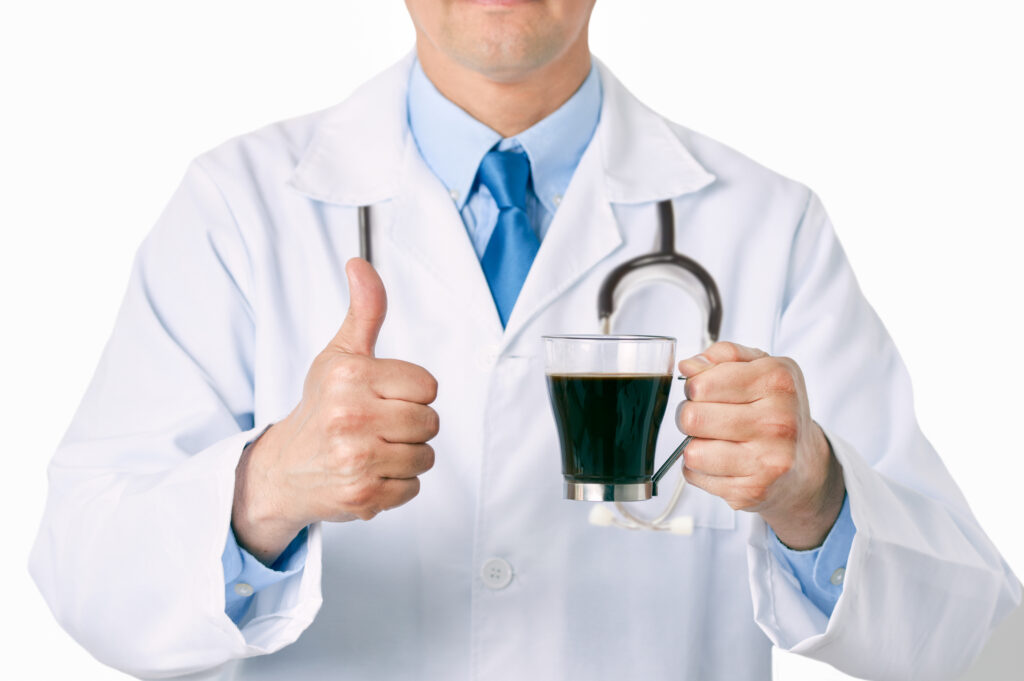 Doctor hands holding a coffee cup with a thumb up of approval